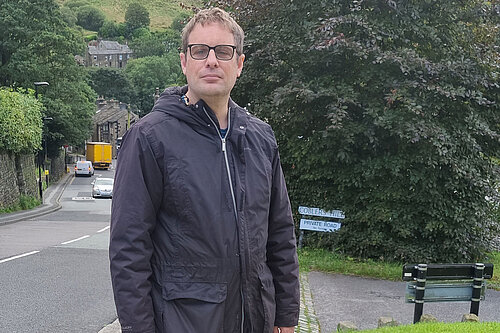 Garth Harkness at one of the grit bin sites, with a steep road behind him